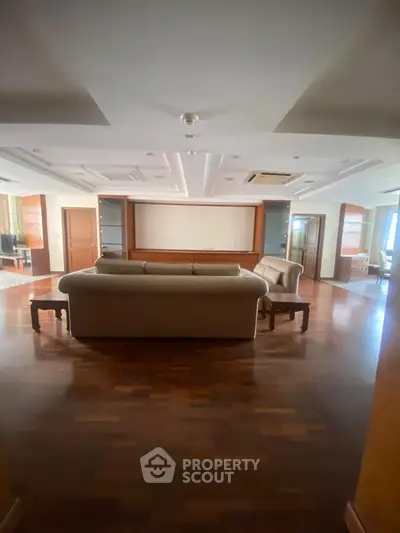 Spacious living room with elegant wooden flooring and modern ceiling design.