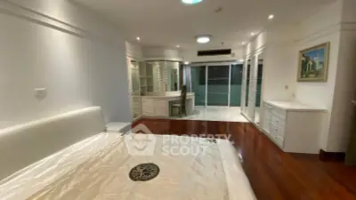 Spacious bedroom with elegant wooden flooring and modern furnishings in a luxury apartment.