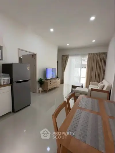 Modern living room with dining area and sleek kitchen appliances in open layout.