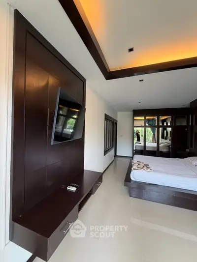 Luxurious bedroom with modern TV setup and elegant ceiling lighting