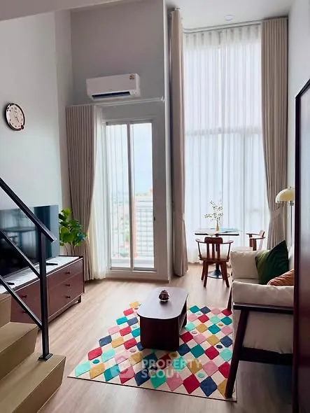 Chic modern living room with high ceilings, large windows, and colorful decor in a stylish apartment.