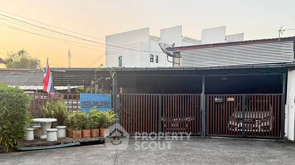 Charming residential property with gated parking and lush greenery in a serene neighborhood.