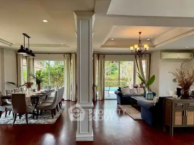 Spacious open-plan living and dining area with pool view, elegant decor, and natural light.