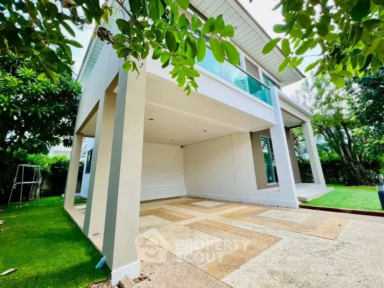 Modern two-story house with spacious outdoor area and lush greenery