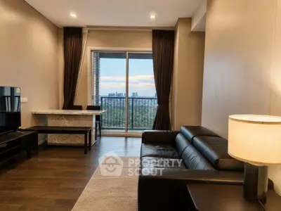 Modern living room with leather sofa and city view balcony, featuring elegant decor and natural light.
