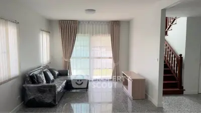 Spacious living room with modern sofa and elegant staircase