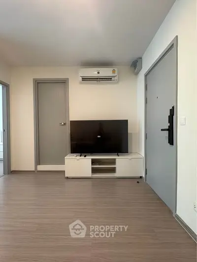 Modern living room with sleek TV setup and air conditioning, perfect for comfortable living.