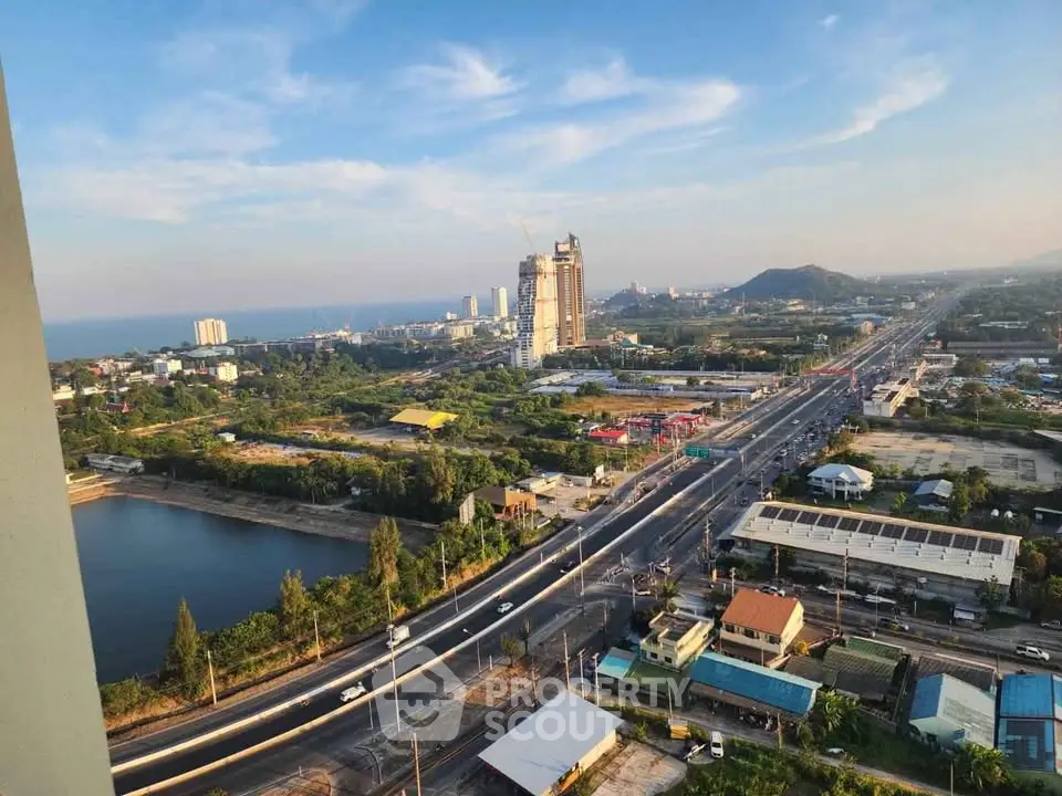 Stunning aerial view of coastal cityscape with ocean and skyline, perfect for real estate investment.