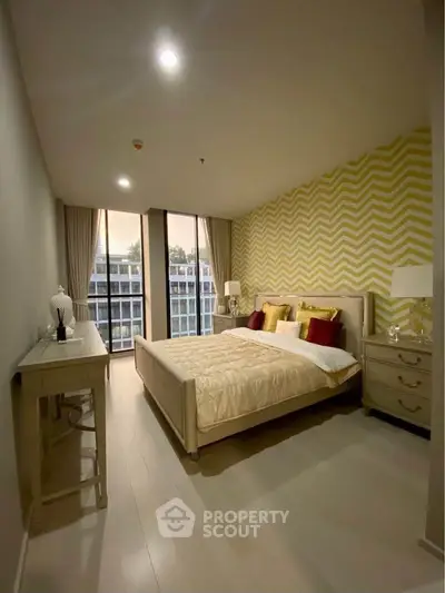 Elegant bedroom with modern decor and large windows offering natural light and a stylish accent wall.
