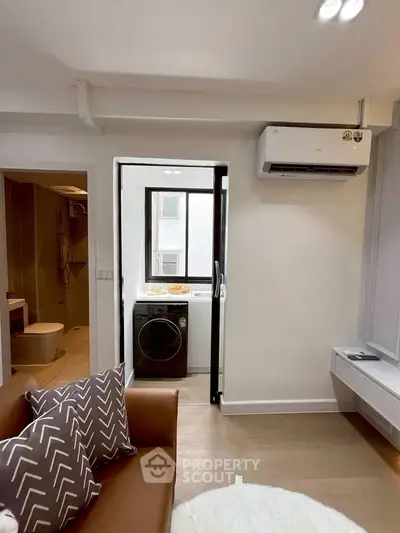 Modern living room with air conditioning and view into laundry area