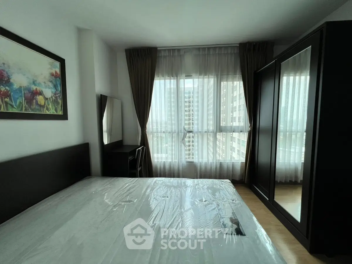 Modern bedroom with large window and stylish furniture in urban apartment