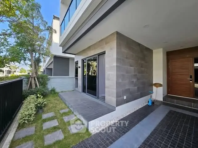 Modern home exterior with sleek design and lush garden