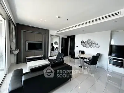 Modern living room with sleek black furniture and stylish decor in a contemporary apartment.
