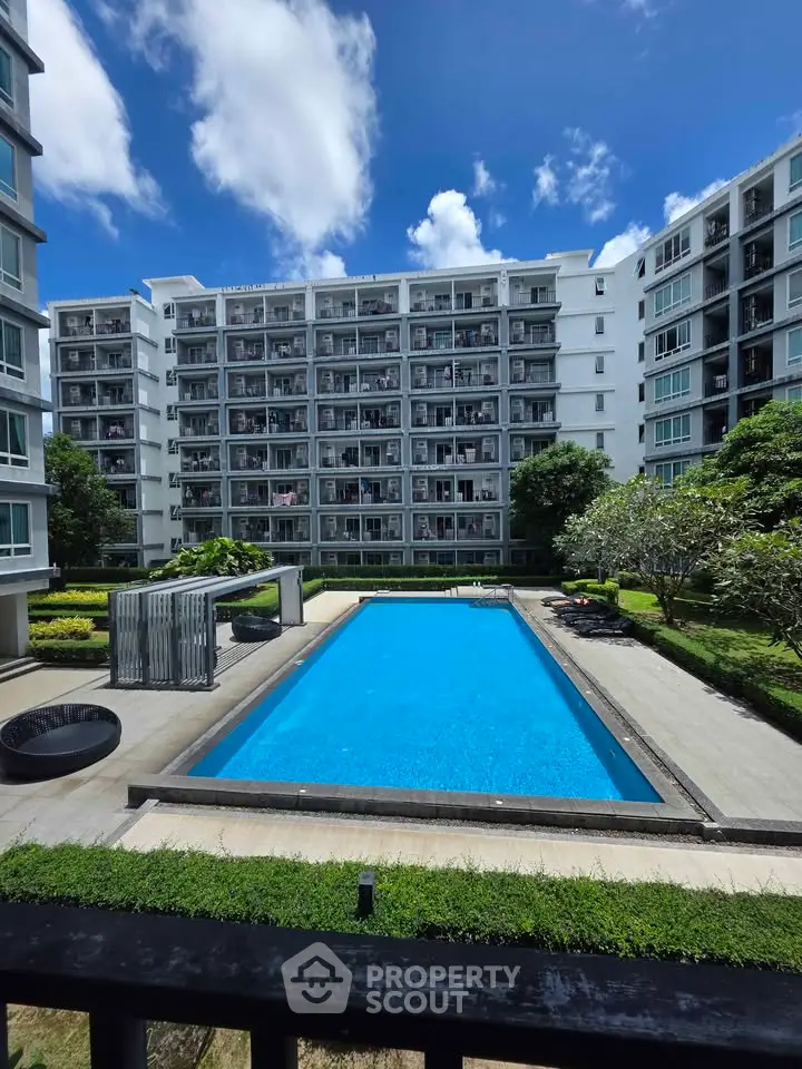 Modern residential building with a pristine swimming pool and lush garden view.