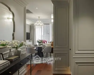 Elegant living room with chandelier and dining area, featuring stylish decor and natural light.