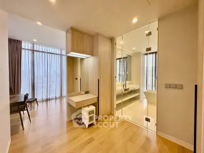 Spacious modern living area with glass partition and wooden flooring