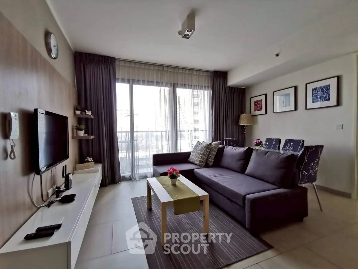 Modern living room with stylish decor and large windows offering natural light.