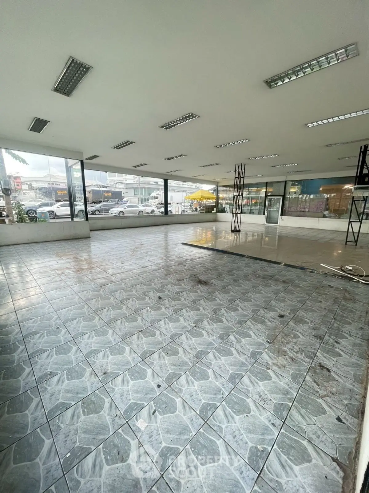 Spacious commercial space with large windows and tiled flooring, ideal for retail or office use.
