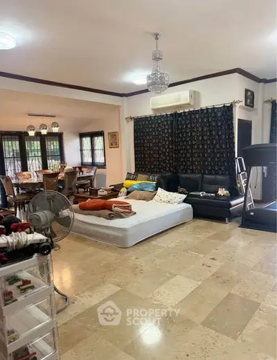 Spacious living room with elegant decor and natural light, featuring a cozy seating area and modern amenities.