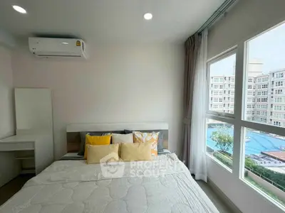 Bright bedroom with pool view in modern apartment, featuring cozy bed and air conditioning.