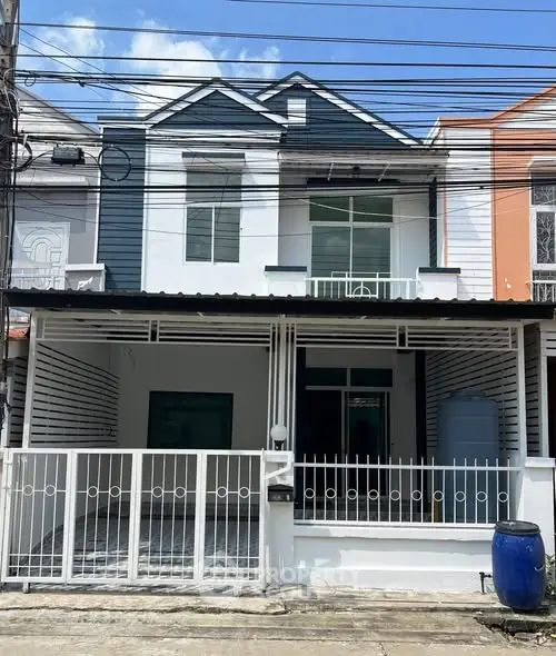 Charming two-story townhouse with modern facade and gated entrance.