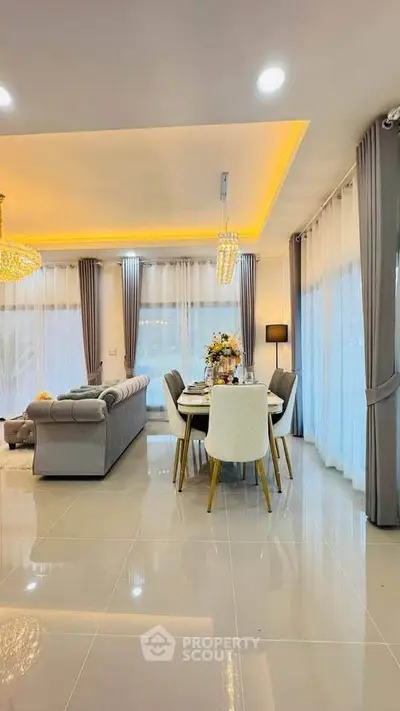 Luxurious open-plan living and dining area with elegant decor and modern lighting.