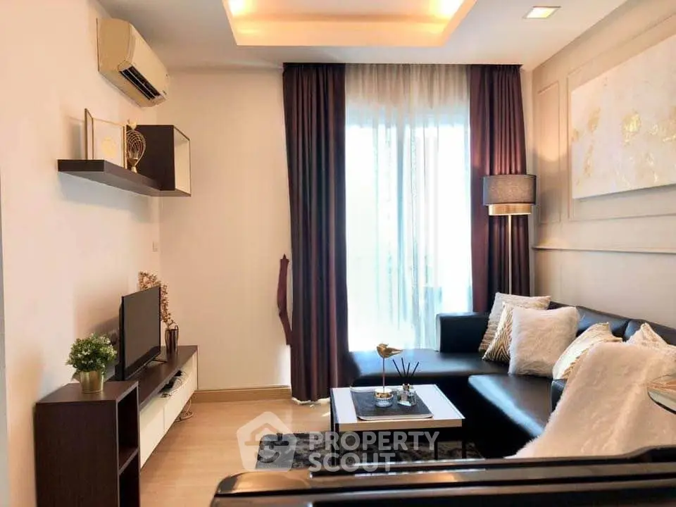 Modern living room with stylish decor, cozy seating, and natural light from large window.