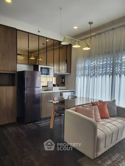 Modern open-layout kitchen and living area with sleek appliances and cozy seating.