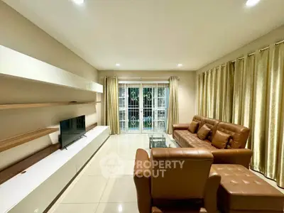 Spacious living room with modern leather furniture and sleek entertainment unit.