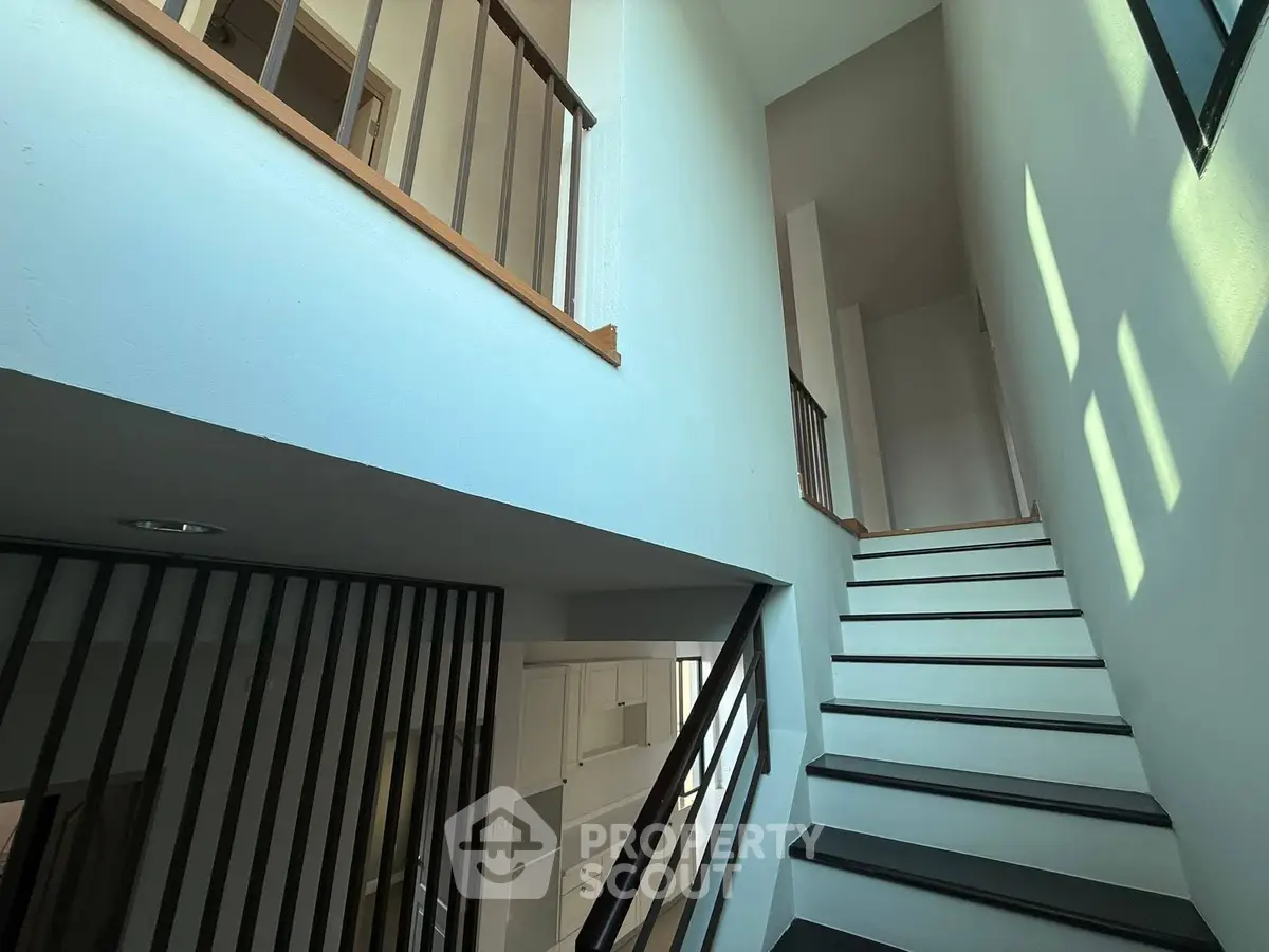 Modern staircase with sleek design and natural light in a contemporary home interior.