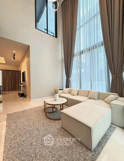 Luxurious high-ceiling living room with elegant curtains and modern furniture