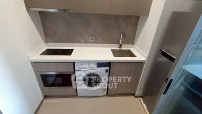 Modern compact kitchen with integrated appliances and sleek design