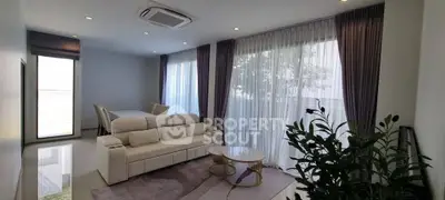 Elegant living room with large windows and modern furnishings, perfect for relaxation and entertaining.