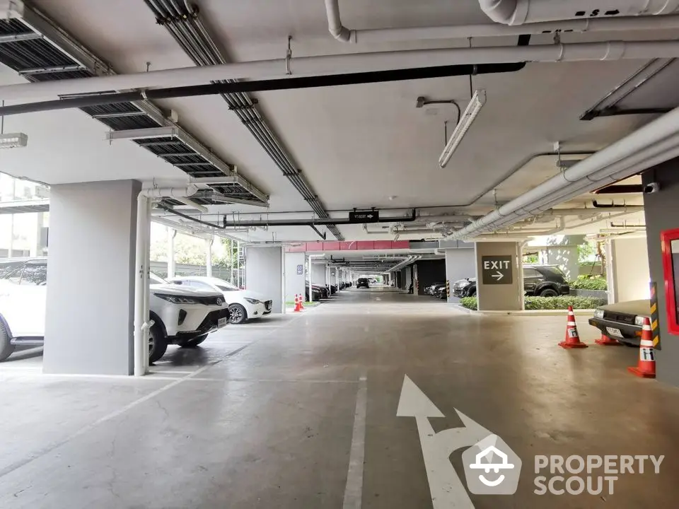 Spacious underground parking area with ample lighting and clear exit signs.