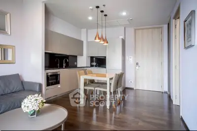 Modern open-layout kitchen and dining area with sleek design and stylish lighting.