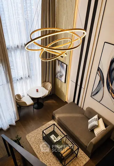 Luxurious modern living room with high ceilings, elegant chandelier, and stylish decor.