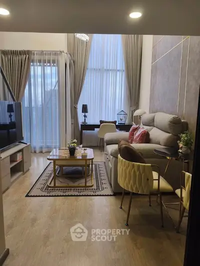 Stylish living room with high ceilings, modern furniture, and large windows for natural light.