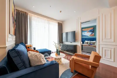 Luxurious living room with elegant decor and cozy seating, featuring a view into a stylish bedroom.