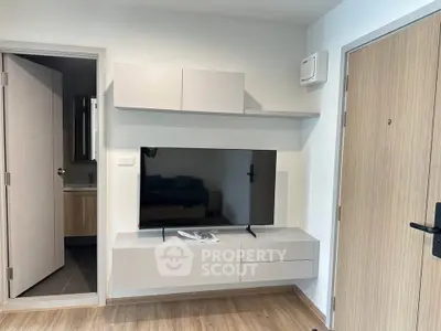 Modern living room with sleek TV setup and wooden flooring