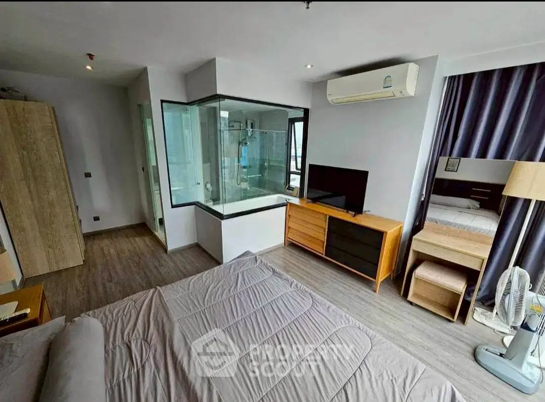Modern bedroom with glass-enclosed shower and sleek furnishings