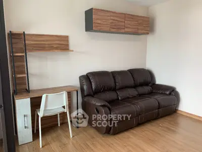 Modern living room with leather sofa and wooden desk, perfect for cozy relaxation.