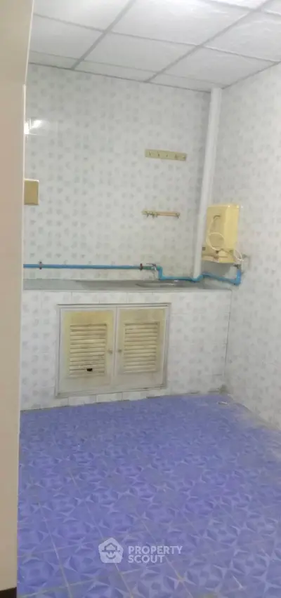 Unfurnished utility room with tiled walls and floor, featuring plumbing fixtures.