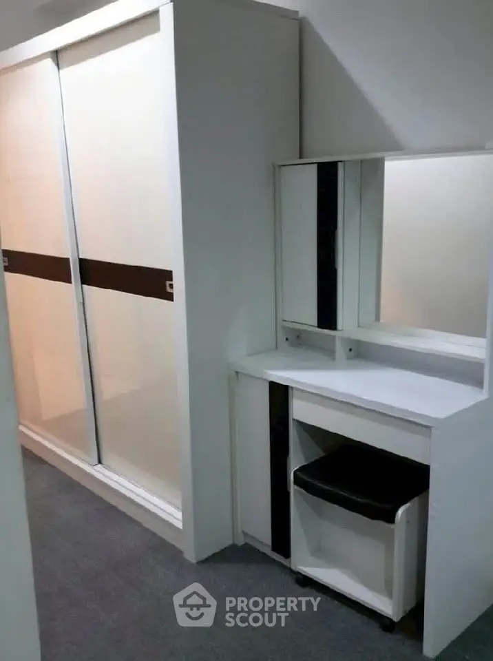 Modern bedroom with sleek wardrobe and stylish vanity in a contemporary apartment.