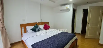 Cozy bedroom with wooden flooring and modern air conditioning unit