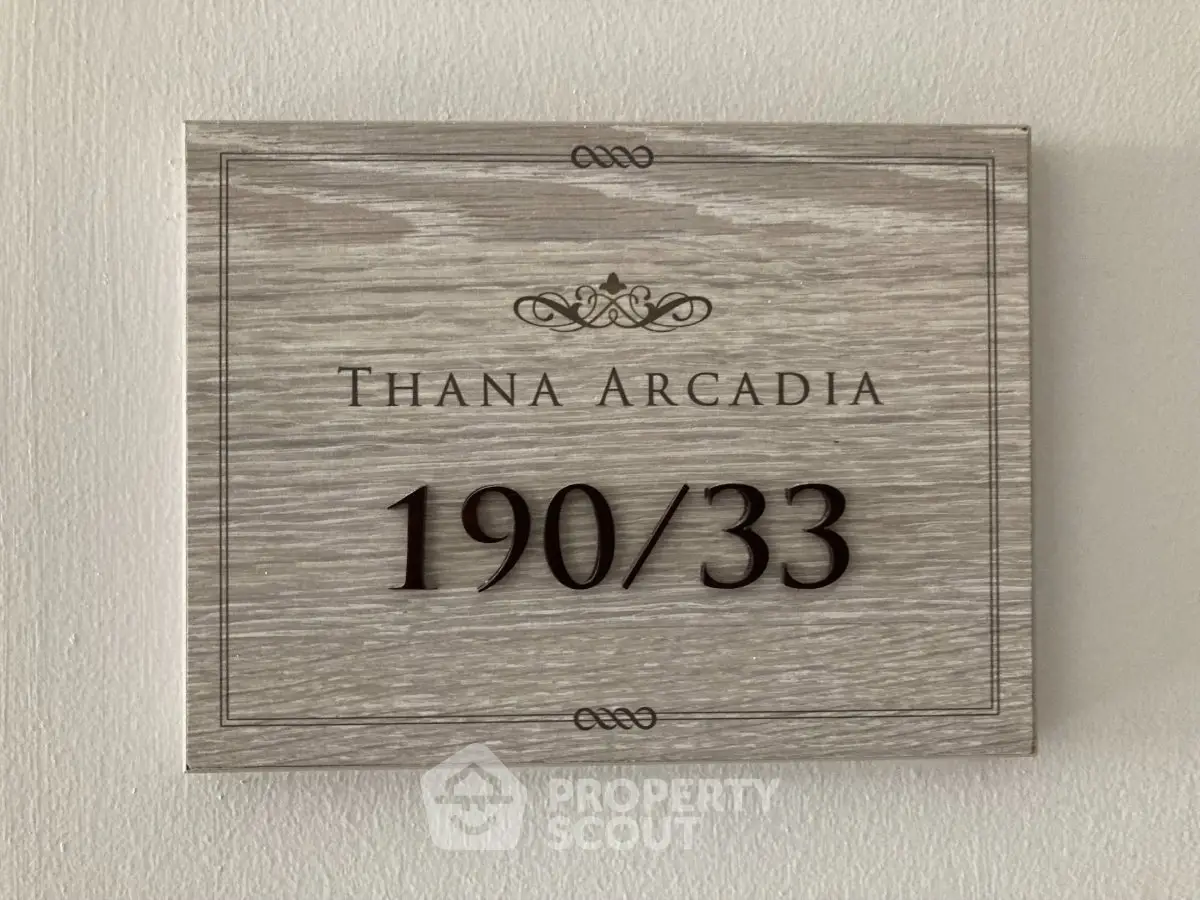 Elegant wooden property sign with unit number 190/33 at Thana Arcadia.