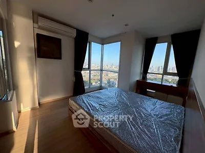 Spacious bedroom with large windows offering stunning city views