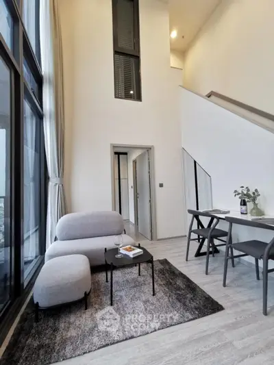 Modern living room with high ceilings and stylish furniture in a contemporary apartment.