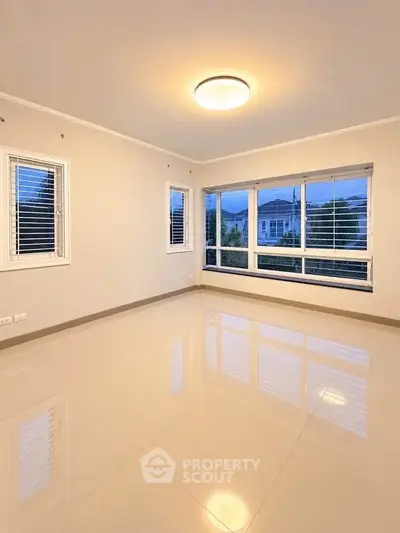 Spacious empty room with large windows and glossy tiled floor, perfect for customization.