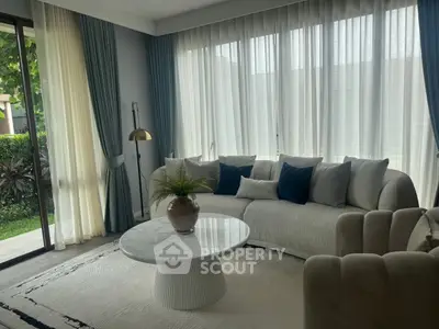 Elegant living room with large windows, stylish sofa, and chic decor