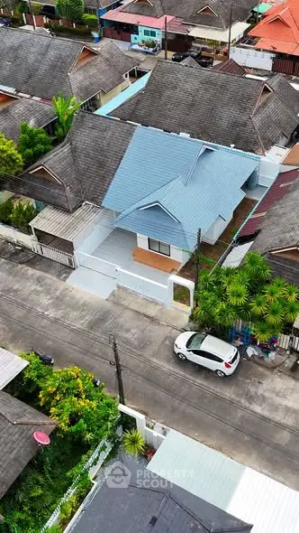 Charming suburban house with blue roof and lush greenery, perfect for family living.